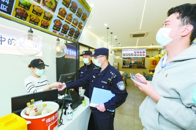 3月14日，南京建邺公安分局莫愁湖派出所严格落实重点场所防疫管理，对辖区“五小场所”开展全覆盖，地毯式摸排。图为民警正在督促小餐饮店实施消毒、体温检测等防疫措施。 南京日报/紫金山新闻记者 段仁虎 摄