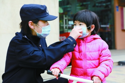 周辰为前来做核酸检测的女儿小葡萄整理口罩。 警方供图
