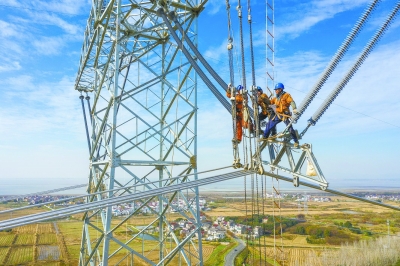 4月13日，白鹤滩—江苏±800千伏特高压直流输电工程（南京段）建设现场，电力施工人员正在架设导线。 通讯员 杜懿 摄 
