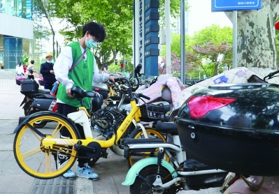 “绿丝带”志愿者正在清理盲道。 南京日报/紫金山新闻记者 甘欣宇 摄