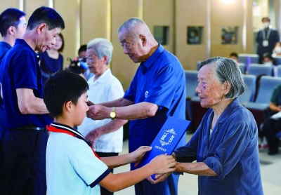 2022年8月15日，夏淑琴曾外孙李玉瀚从夏淑琴手中接过首批“南京大屠杀历史记忆传承人”证书，未来将肩负起接续传承南京大屠杀历史记忆的重任。 南京日报/紫金山新闻记者 孙中元 摄