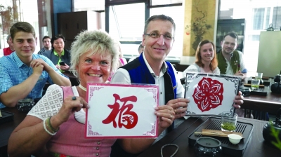 德国迪特福特市代表团成员体验剪纸、茶艺、书法等中国文化。