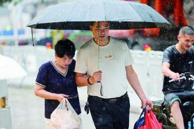 昨天，南京迎来降雨天气，带来片刻凉爽，也给出行的市民带来不便。图为新街口张府园附近，路人在雨中出行。 南京日报/紫金山新闻记者 段仁虎 摄