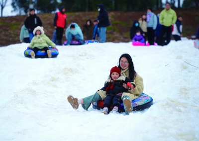 市民游客在浦口区水墨大埝的金陵冰雪大世界体验冰雪游乐项目，享受冰雪乐趣。