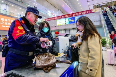 春节假期里，南京南站派出所民警邱广平仔细检查旅客携带的充电宝是否超过规定的容量规格。1965年生的邱广平退伍转业加入铁路公安队伍，已从警38年，今年的春运也是他坚守岗位的最后一次春运。 通讯员 张楠 南京日报/紫金山新闻记者 段仁虎 摄