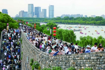 5月3日，众多游客登上有着600多年历史的南京明城墙台城段，远眺城市风光，感受古都的历史底蕴。 南京日报/紫金山新闻记者 徐琦 摄