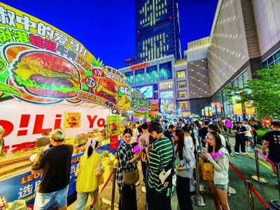 随着夜幕降临，南京“五一”假期的夜晚被点亮，吸引着来自四面八方的游客。他们在灯火辉煌中，在历史与现代交织的氛围里，开启了独特的南京夜之旅。图为在建邺元通商圈举办的2025汉堡节全国巡展上，超30家汉堡品牌齐聚南京，年轻人奔赴一场“美食狂欢”。 南京日报/紫金山新闻记者 段仁虎 摄
