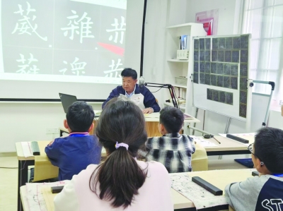 “书法爷爷”何国健在教孩子们书法。 南京日报/紫金山新闻记者 王怀艳 摄
