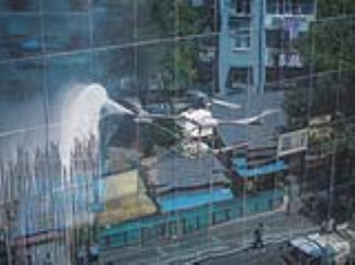 5月29日，位于鼓楼区的华侨大厦外立面清洗，迎来了“无人机+机器人”的协同作业。图为无人机清洗楼宇外立面。 南京日报/紫金山新闻记者 董家训 摄 
