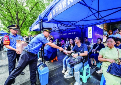 6月7日，南京市各区城管全面启动高考保障工作。图为玄武区城管局执法人员在南京第九中学高考点大门前设立护考点。 南京日报/紫金山新闻记者 董家训 摄