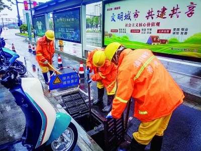 6月21日，南京迎来雨水天气，各区各街道城管、环卫迅即启动应急保障预案，对路面积水进行及时清扫，确保雨水及时排走，保障市民出行安全。图为浦口综合行政执法局市政部门在龙华路清理下水口助排。 通讯员 杨钦云 南京日报/紫金山新闻记者 董家训 摄