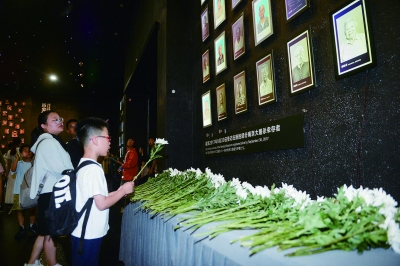 7月2日，照片墙上，刘贵祥、谢桂英两位老人的照片由彩色变为黑白，家属和志愿者、工作人员等一起献花默哀。 南京日报/紫金山新闻记者 孙中元 摄
