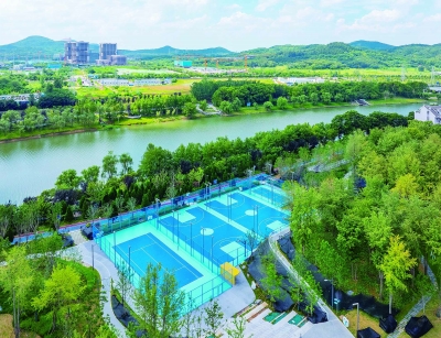 7月8日，秦淮新河风光带两桥段绿意葱茏，昔日杂乱河岸荒地经整治，成为串联生态与生活的滨水长廊。 南京日报/紫金山新闻记者 冯芃 沐剑平 摄