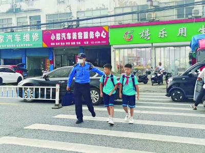 雨花台区城管板桥中队队员护送学生过马路。 雨花台区城管板桥中队供图