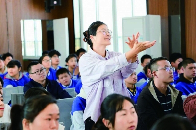 学生在台上表演，王倩老师在台下用手语指挥。 学校供图