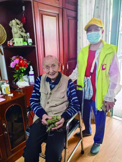 社区工作人员给百岁老人朱鸣皋送来粽子。 迅捷居家养老服务中心供图
