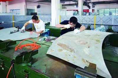 在东华汽车实业有限公司培训中心，学员正在训练汽车钣金修复项目技能。