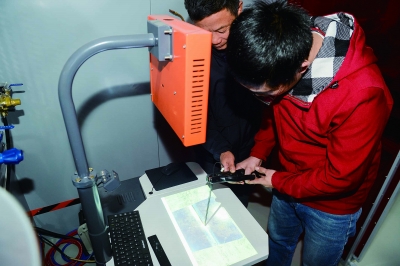 焊工技师正在指导学员手持模拟焊枪操作杆，练习焊缝控制技巧。