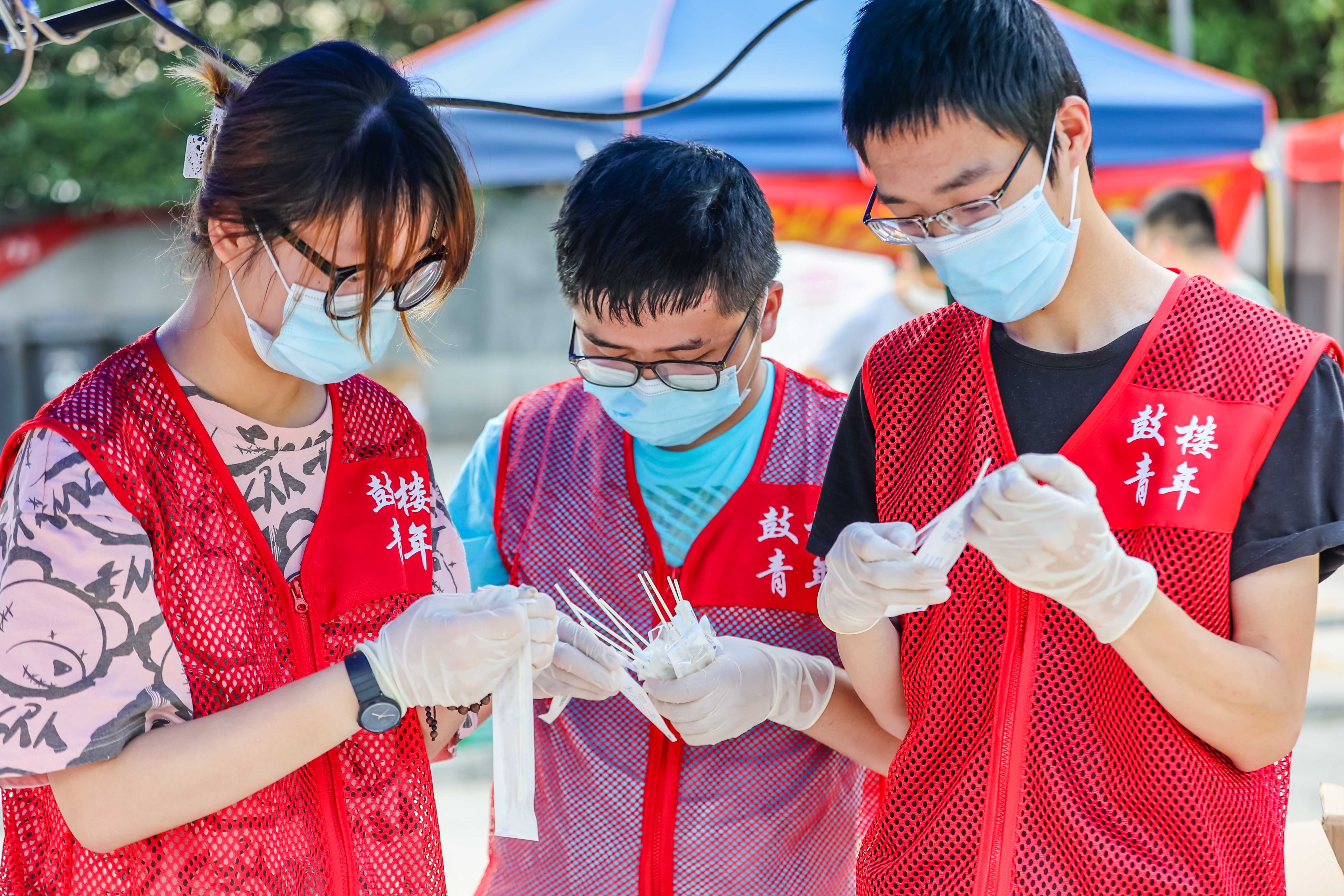 南京青年志愿者们积极参与辖区内各个社区核酸检测点的人员预约登记、资料填写、秩序维护和知识宣讲解答等工作。图为鼓楼区大学生志愿在核酸检测一线提供志愿服务。 通讯员 盛伟 南报融媒体记者 董家训 摄