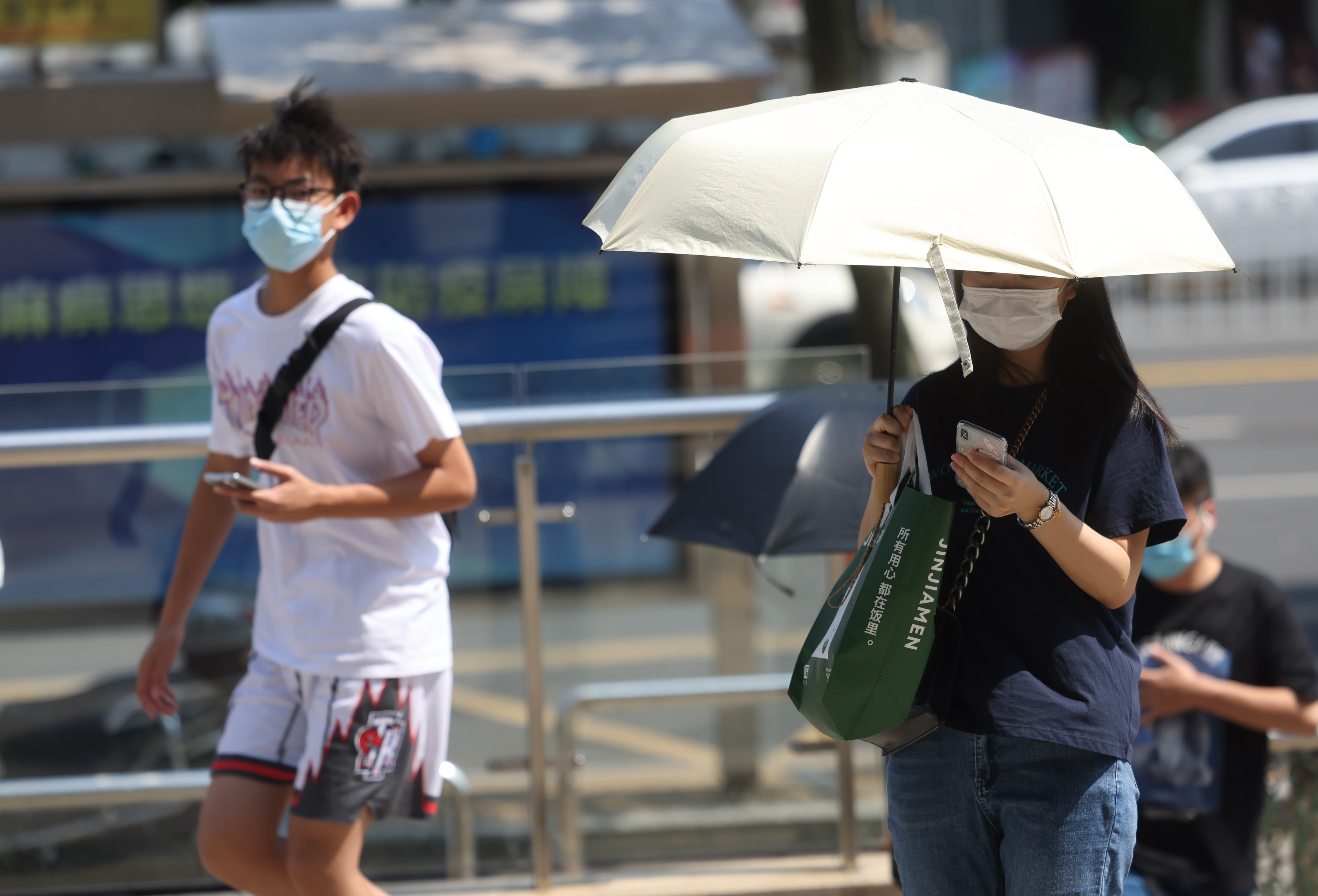 这几天持续高温天气，热浪滚滚，市民撑伞走在珠江路街头。 南京日报/紫金山新闻记者 徐琦 摄