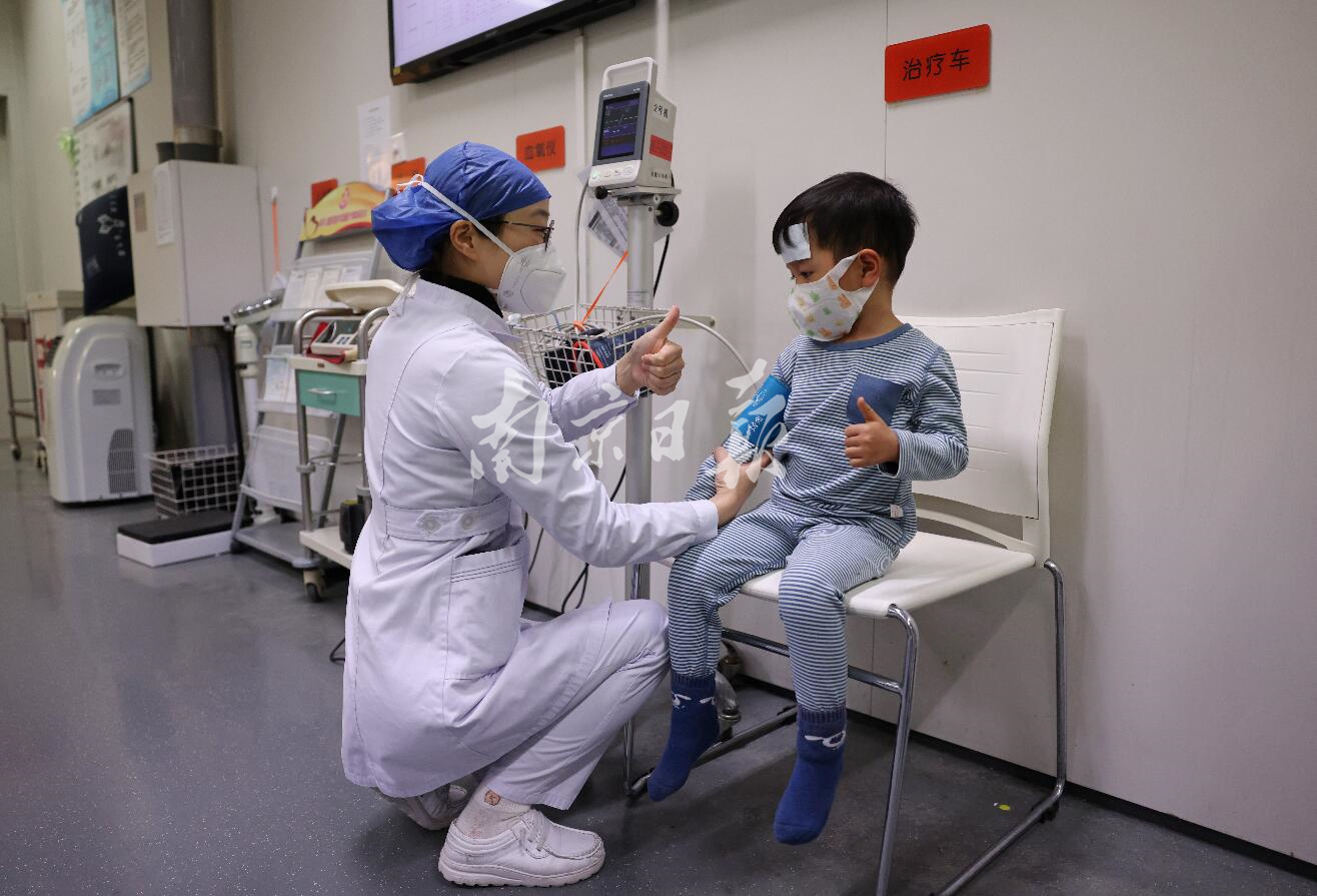 2022年12月27日夜间，南京市儿童医院急诊，医护人员为小朋友竖起大拇指以示鼓励。