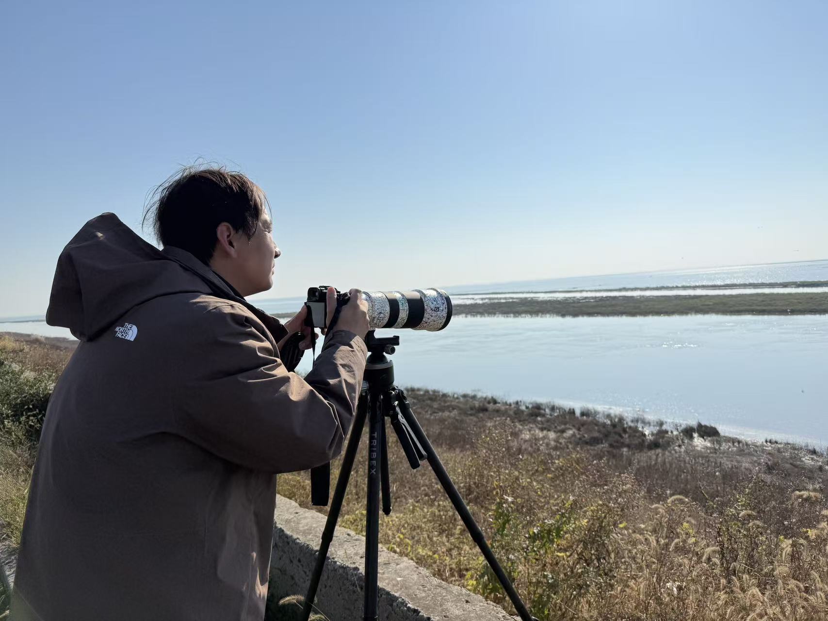 正在石臼湖畔拍鸟的哈敏哲。 记者 杜莹 摄