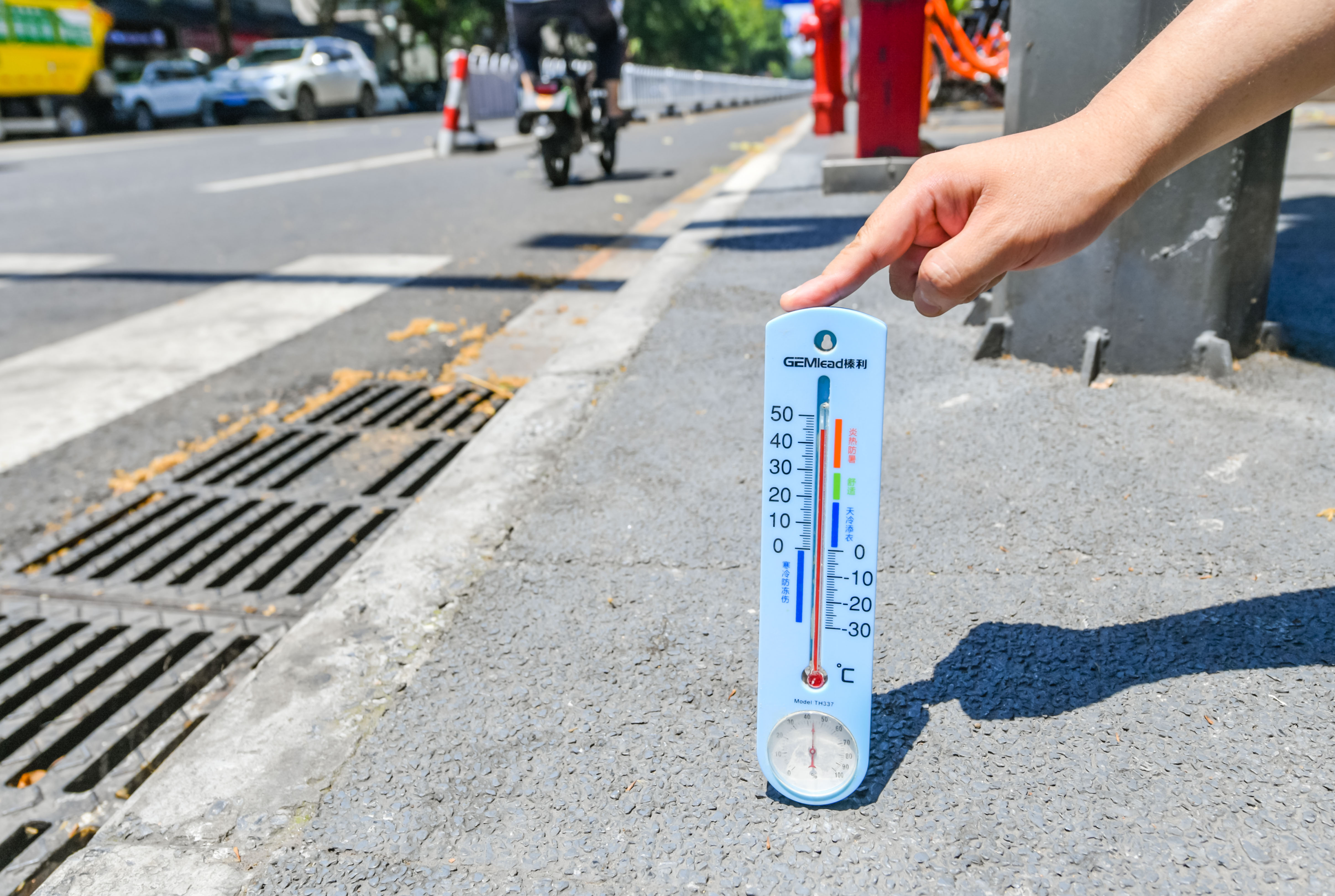 7月12日，我市最高气温达到37℃，有些马路地表温度已达到45℃，气象部门发布高温橙色预警。在马道街，环卫工人冒着酷暑，反复清洗道路和马路中的护栏。 南报融媒体记者 董家训 摄