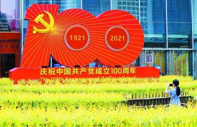 新街口的庆祝中国共产党成立100周年组合雕塑，引得市民驻足。 