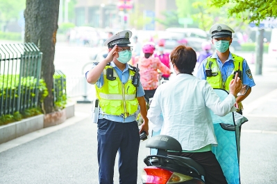 交警对骑乘电动自行车不佩戴头盔的违法行为进行现场处罚。 南报融媒体记者 段仁虎 摄